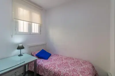 a bedroom with a bed with a blue pillow on it at Bed&BCN Park Güell in Barcelona