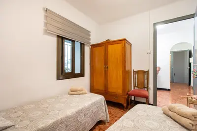 a bedroom with two beds and a cabinet and a mirror at Casa turística Cunit in Cunit
