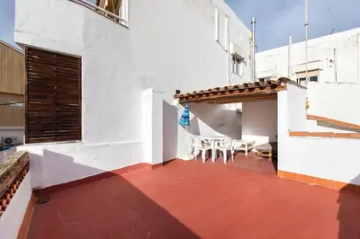 a balcony of a white house with a table and chairs at Casa turística Cunit in Cunit
