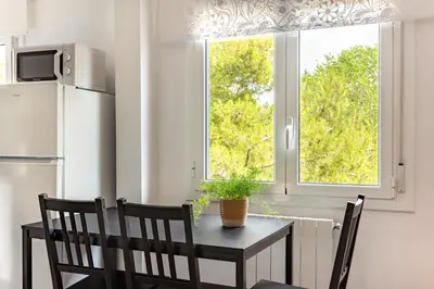 a dining room table with two chairs and a window at Barca 3 New Lovely aprtment Near Beach in Sant Adria de Besos
