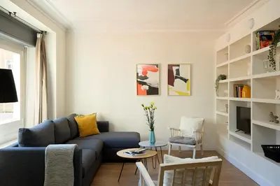 a living room with a blue couch and a tv at Casa Cosi - Casanova 2 in Barcelona