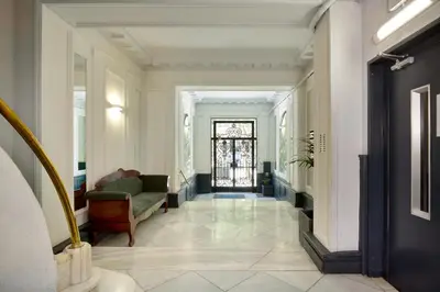 a hallway with a green chair and a door at Casa Cosi - Casanova 2 in Barcelona