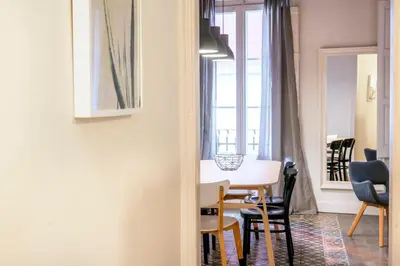 a dining room and living room with a table and chairs at Casa Cosi - Putxet 3 in Barcelona