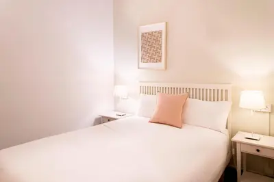 a bedroom with a white bed and two night stands at Casa Cosi - Sant Gervasi 3 in Barcelona