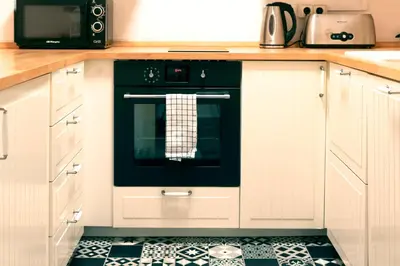 a kitchen with a black oven with a tile floor at Casa Cosi - Sant Gervasi 3 in Barcelona