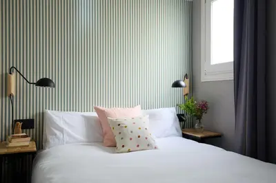 a bedroom with a white bed with pink pillows at Casa Cosi - Terrace 1 in Barcelona