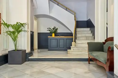 a lobby with a staircase with a chair and a couch at Casa Cosi - Casanova 3 in Barcelona