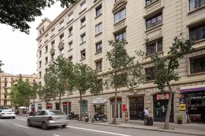 a large building on a city street with cars at Casa Cosi - Casanova 3 in Barcelona