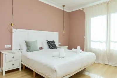 a bedroom with a large white bed and a window at Casa Cosi - Casanova 6 in Barcelona