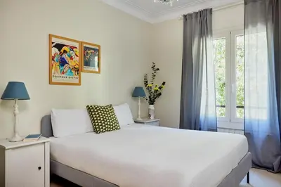 a bedroom with a white bed and a window at Casa Cosi - Casanova 1 in Barcelona