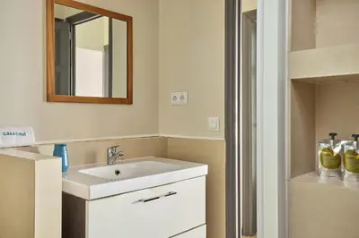 a bathroom with a white sink and a mirror at Casa Cosi - Casanova 1 in Barcelona