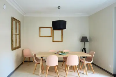 a dining room with a wooden table and pink chairs at Casa Cosi - Casanova 1 in Barcelona