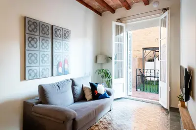 a living room with a couch and a sliding glass door at Casa Cosi - Putxet 1 in Barcelona