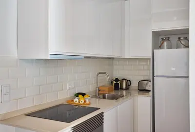 a white kitchen with a sink and a refrigerator at Casa Cosi - Sant Gervasi 4 in Barcelona