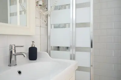 a white bathroom with a sink and a shower at Casa Cosi - Francoli 4 in Barcelona