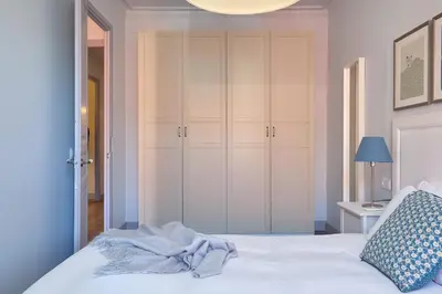 a bedroom with a white bed with a blue pillow at Casa Cosi - El Farro 2 in Barcelona