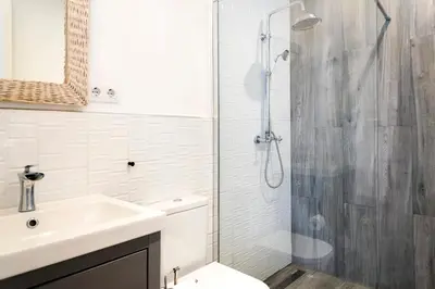 a white bathroom with a shower and a sink at Casa Cosi - La Gleva 3 in Barcelona