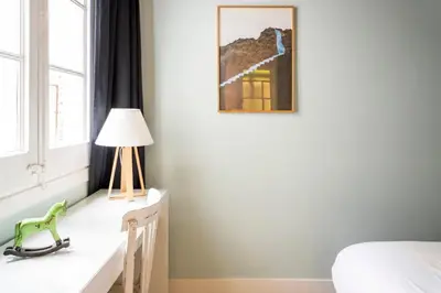 a bedroom with a bed and a lamp and a window at Casa Cosi - La Gleva 3 in Barcelona