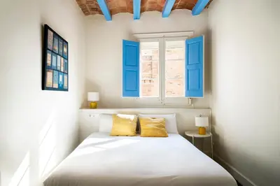 a bedroom with a bed with two yellow pillows at Casa Cosi - La Gleva 4 in Barcelona