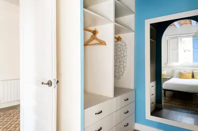 a bedroom with a white closet with a mirror at Casa Cosi - La Gleva 4 in Barcelona