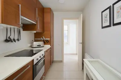 a kitchen with wooden cabinets and a stove top oven at Casa Cosi - Casanova 4 in Barcelona