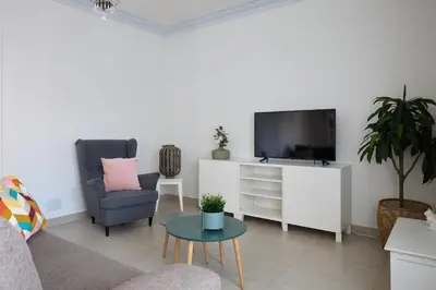 a living room with a tv and a chair and a table at Casa Cosi - Casanova 4 in Barcelona