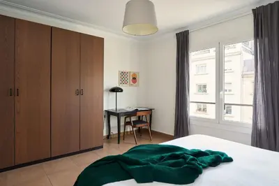 a bedroom with a bed with a green blanket on it at Casa Cosi - Casanova 7 in Barcelona