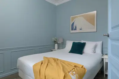 a blue bedroom with a white bed with a blanket on it at Casa Cosi - El Farro 1 in Barcelona