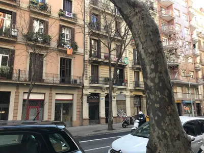 a street with cars parked in front of buildings at Rosselló Apartment in Barcelona
