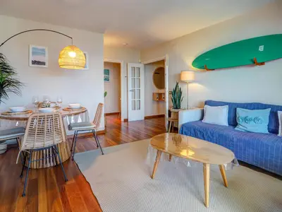 a living room with a blue couch and a table at Balmins Surf by Hello Homes Sitges in Sitges