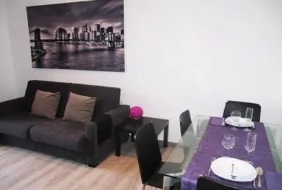 a living room with a couch and a dining table at Paseo de Gracia Apartments in Barcelona