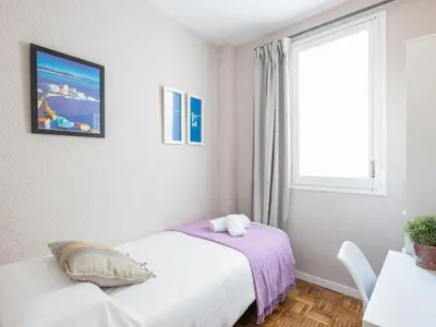 a white bedroom with a bed and a window at Clot market in Barcelona
