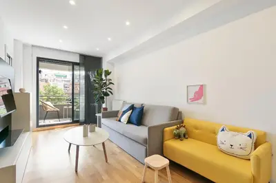 a living room with a yellow couch and a table at Sardenya Apartment by Olala Homes in Barcelona