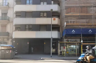 a man riding a motorcycle in front of a building at Sardenya Apartment by Olala Homes in Barcelona