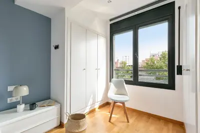 a white chair in a room with a window at Sardenya Apartment by Olala Homes in Barcelona