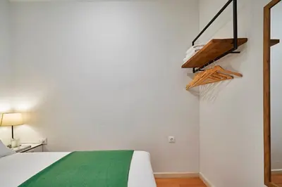 a bedroom with a bed with a green blanket at Love Local Life Near Sagrada Familia by MyRentalHost in Barcelona