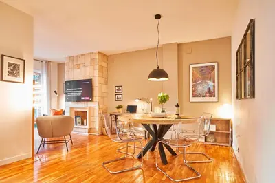 a living room with a table and chairs and a fireplace at Love Local Life Near Sagrada Familia by MyRentalHost in Barcelona
