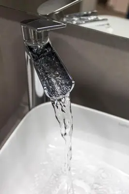 a stream of water pouring from a faucet over a sink at 8 lacus in Hospitalet de Llobregat
