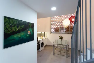 a kitchen and a living room with a tv on a wall at 8 lacus duplex in Hospitalet de Llobregat