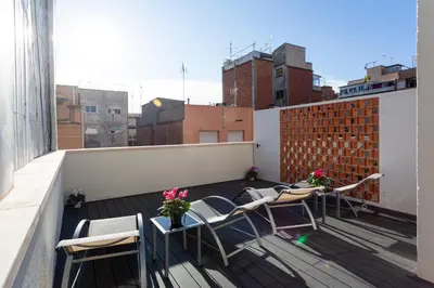 a balcony with chairs and tables on a roof at 8 lacus duplex in Hospitalet de Llobregat