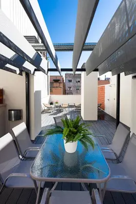 a balcony with a glass table and chairs at 8 lacus duplex in Hospitalet de Llobregat