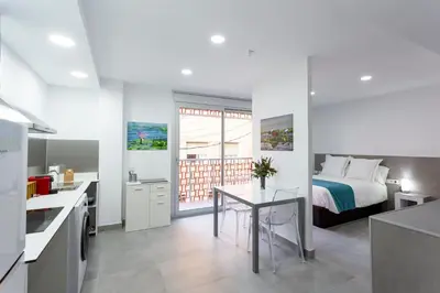 a kitchen and a bedroom with a bed and a table at 8 lacus VICTORIA in Hospitalet de Llobregat