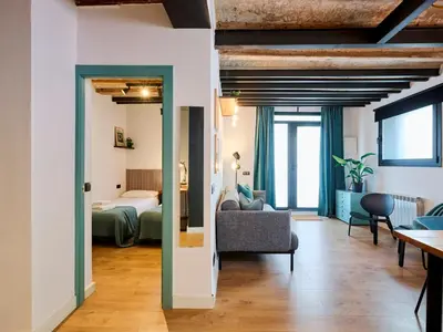 a living room with a bed and a room with a couch at Casa Wilson by MyRentalHost in Barcelona