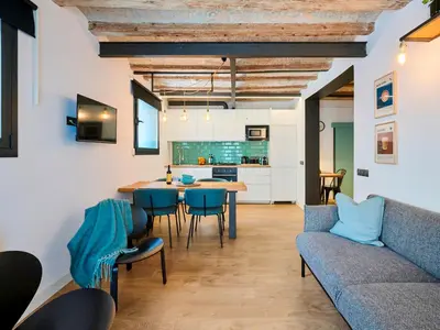 a kitchen and living room with a couch and a table at Casa Wilson by MyRentalHost in Barcelona