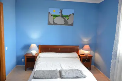 a blue bedroom with a bed and two nightstand tables at Sea view, Wonderful pool, Nature, Peaceful & AC in Sant Cebrià de Vallalta