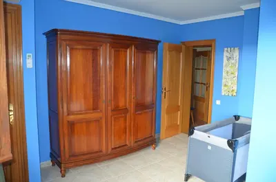 a large wooden cabinet in a room with blue walls at Sea view, Wonderful pool, Nature, Peaceful & AC in Sant Cebrià de Vallalta