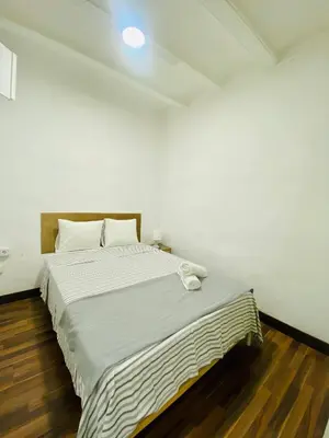 a white bed in a room with a wooden floor at 08 Apartament lof 3 2 in Barcelona
