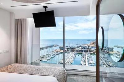 a bedroom with a large window with a view of a marina at Hotel Marina Badalona in Badalona