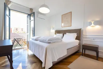 a white bedroom with a bed and a balcony at Majestic 4BR/4BATH apartment in Sagrada Familia area in Barcelona