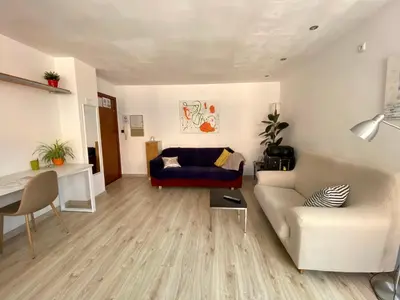a living room with a couch and a table at Piscina en Centro de Terrassa in Terrassa